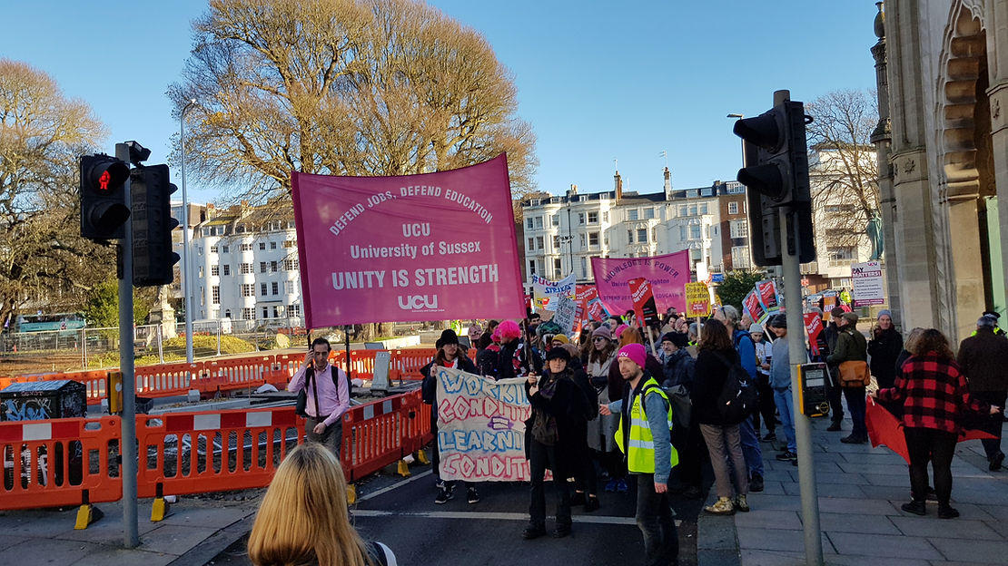 A group of protesters in the street with UCU Sussex and UCU Brighton banners