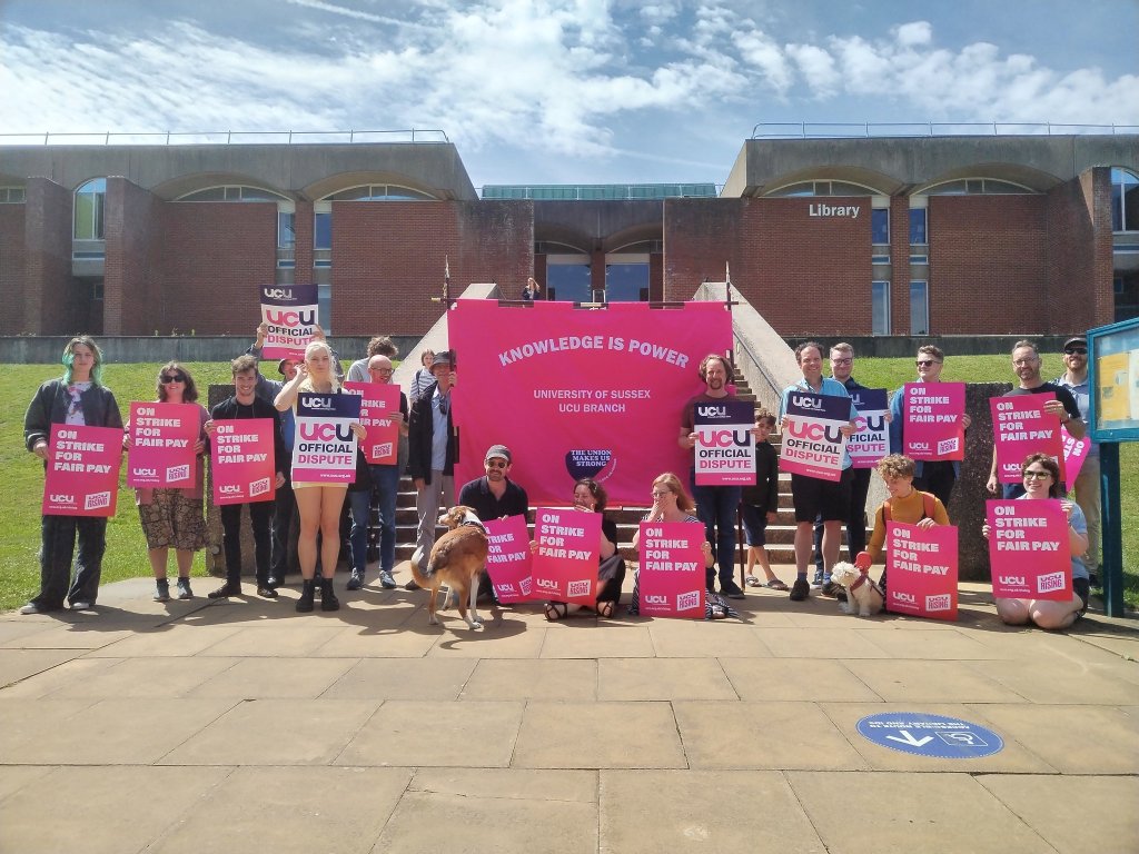 Sussex UCU branch gather in front of Sussex Library with placards and signs during a strike day.